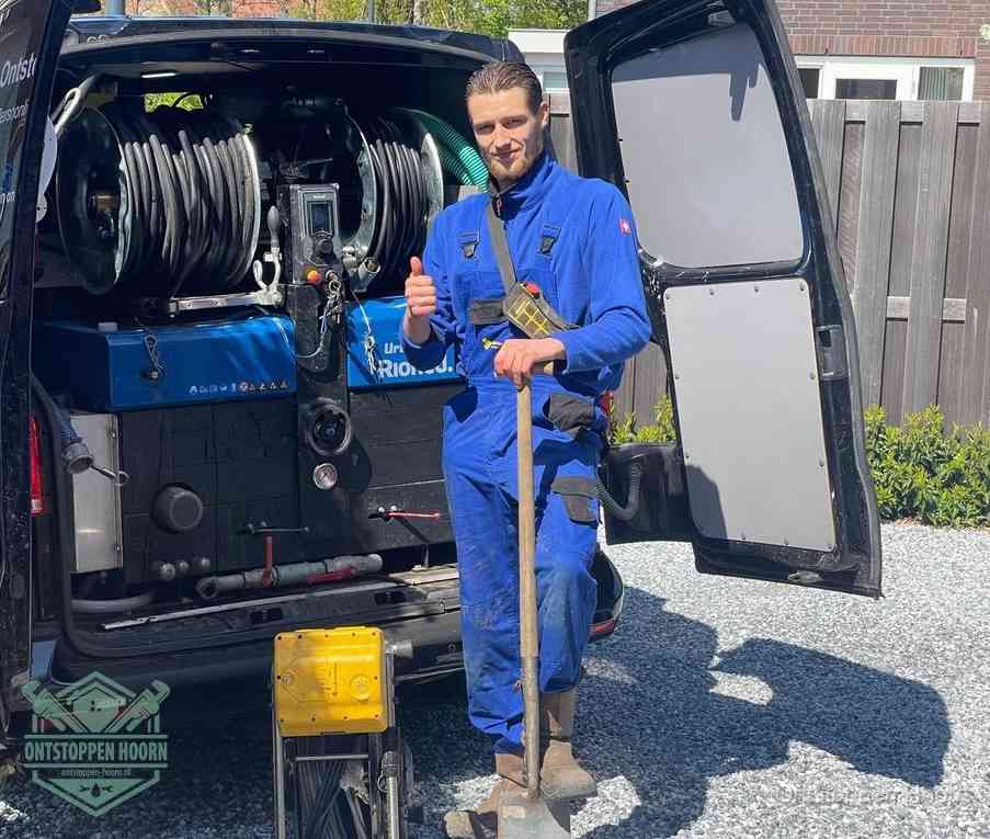 Een tevreden monteur met opgestoken duim naast de bestelbus, slim ingrijpen bespaart kosten bij een verstopte afvoer in Hoorn