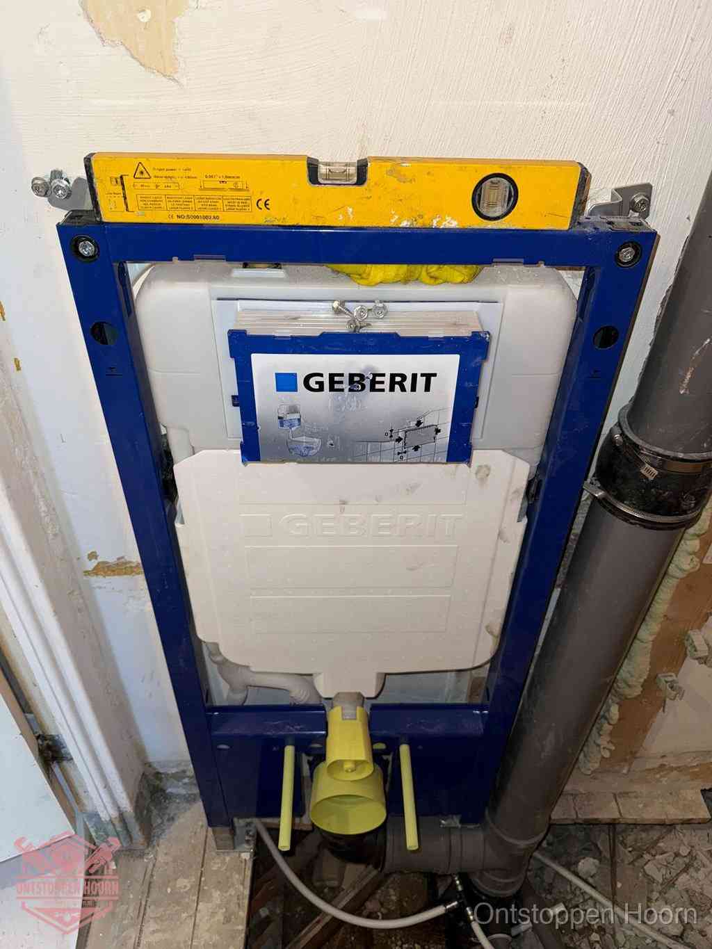 Een Geberit inbouwreservoir met frame voor een hangtoilet tegen de wand, met de afvoerbocht naar de vloer, kenmerkend voor een verstopt hangtoilet in Hoorn