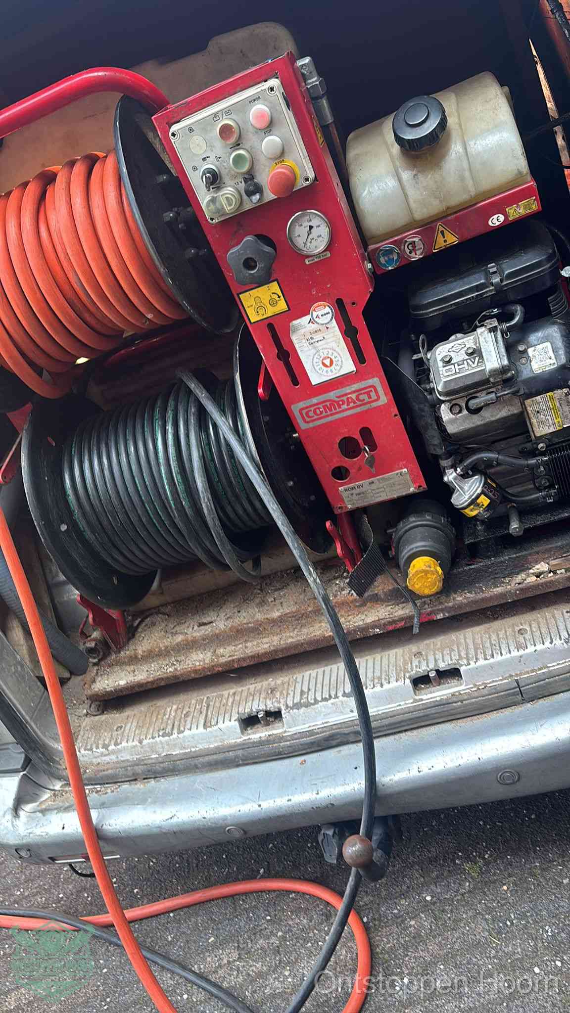 Een rood hogedruk-rioolreinigingstoestel in de laadbak van de bedrijfsbus, apparatuur voor een hardnekkige afvoerverstopping in Hoorn
