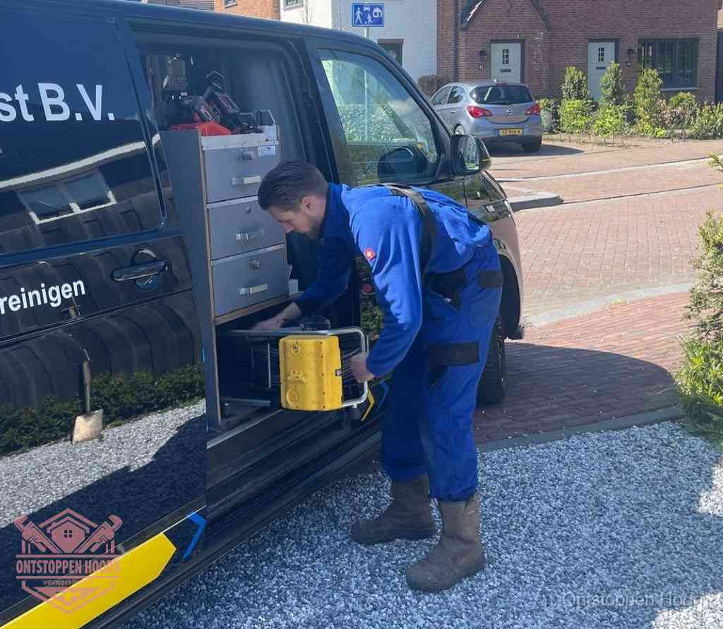 Een monteur pakt apparatuur uit de bedrijfsbus voor service aan huis, het moment om een professional in te schakelen in Hoorn