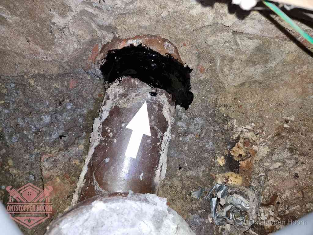 Een oude gres rioolbuis met een beschadigde koppeling onder de vloer, oorzaak van terugkerende structurele wc-problemen in Hoorn